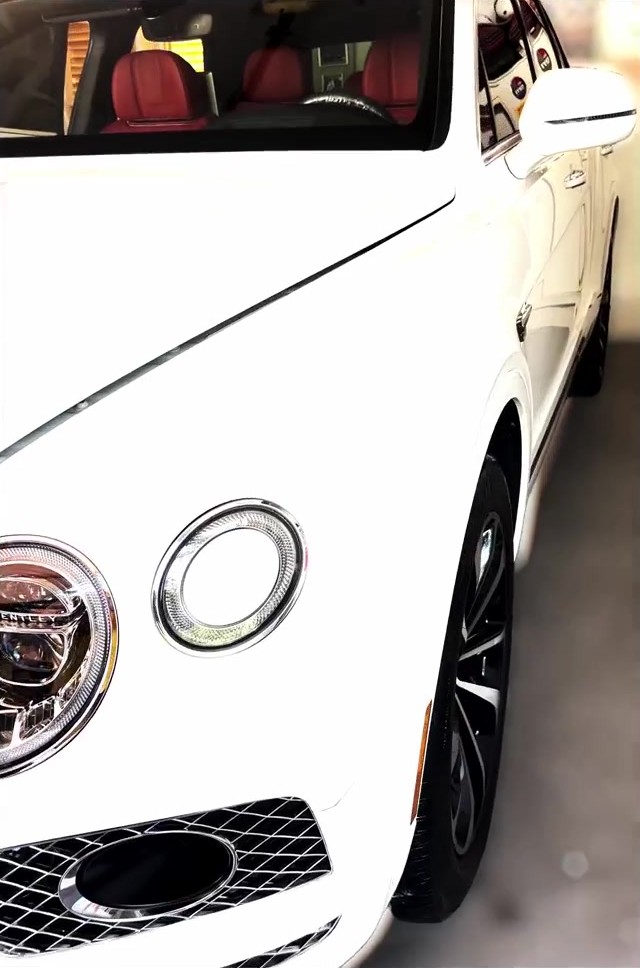 Finished white Bentley showing its bonnet, headlight and front wing after polishing and ceramic coating